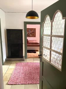 弗罗伊登施塔特1 - 2 Zimmer in historischem Altstadthaus的通往客厅的开放式门,客厅铺有红色地毯