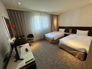 台南扬悦精致大饭店台南馆的酒店客房设有两张床和电视。