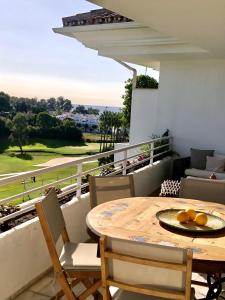 马贝拉Duplex vistas al golf Guadalmina Marbella的美景阳台配有桌椅