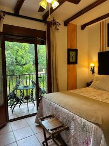 阿罗约弗里奥德拉谢拉圣玛丽亚修道院乡村酒店的一间卧室配有一张床,阳台配有桌子