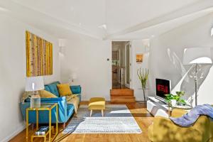 伦敦3 Bedroom Mews Home - Clapham Common - Free Private Parking - Sleeps 5 - Newly Refurbished - Sweetpea & Pillow Properties的客厅配有蓝色的沙发和黄色的椅子
