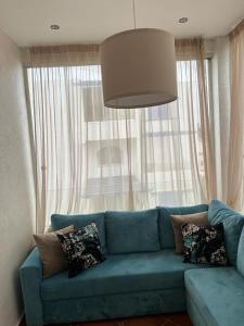 卡博尼格洛Luxury resident with pool的客厅设有一张蓝色的沙发,配有大窗户