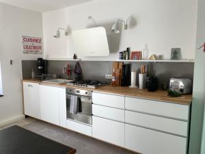 索林根Haus mit Türmchen的厨房配有白色橱柜和炉灶。