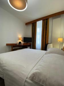 日内瓦海军司令酒店的卧室配有一张白色大床和一张书桌
