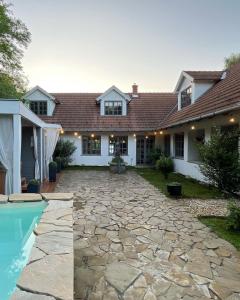 Tilaj44 George House - Pool, Jacuzzi, Sauna, View的一座带石头庭院和游泳池的房屋