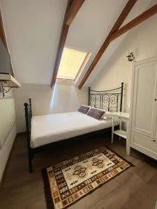 舒加塔格盐矿镇Casa Moldovan ( Coltisorul meu de rai)的一间卧室配有一张带窗户和地毯的床