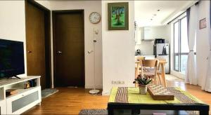 马尼拉Modern and Comfortable Staycation - Unit 3718 Novotel Tower的客厅配有桌子和墙上的时钟