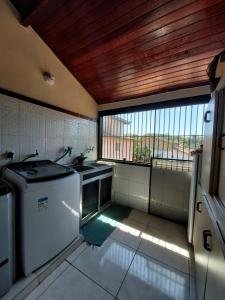 布希奥斯Flats Tartaruga Búzios的厨房配有洗衣机和窗户。