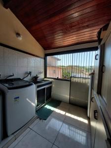 布希奥斯Flats Tartaruga Búzios的一个带水槽和窗户的小厨房