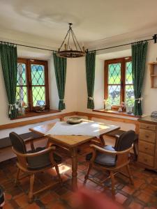 湖滨福煦Ferienwohnung am Fuschlsee的一间带桌椅和窗户的用餐室