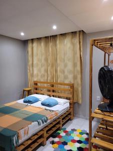 MartinsAluguel Temporada em Martins/RN的一间卧室配有一张木床和风扇