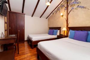 昆卡卡萨圣拉斐尔酒店的酒店客房设有两张床、一张桌子和一台电视。