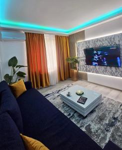 普洛耶什蒂Cazare Ploiesti的客厅配有蓝色的沙发和平面电视。