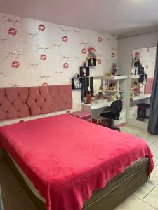 布卢梅瑙Pousada Tia Moni的一间卧室配有粉红色的床和墙上写字的墙壁