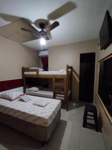 圣保罗Hotel cowboy Cidade Dutra的客房设有两张床和吊扇。