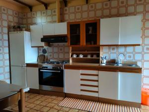 特尔尼Antica Terrazza的厨房配有白色橱柜和炉灶烤箱。
