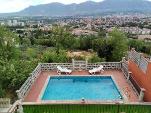 特尔尼Antica Terrazza的一个带椅子的游泳池,享有城市美景