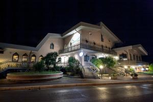 切塞纳蒂科拉伯罗多酒店的一座建筑,晚上在它旁边有一个钟