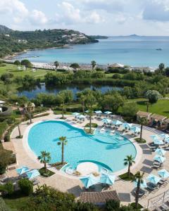 罗通多港阿比多露酒店的享有带椅子和遮阳伞的游泳池的上方景致