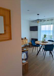 圣普里安海滩"La Sorra" Résidence en Bord de mer的用餐室以及带桌椅的起居室。