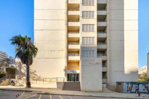 波尔蒂芒Rocha Gardens Apartment的一座高大的建筑,前面有一棵棕榈树