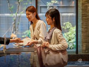 京都京都四条乌丸大和ROYNET酒店的两个女人站在桌子旁边