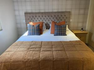 Port CharlotteLochindaal Hotel的一间卧室配有一张带蓝色和橙色枕头的大床