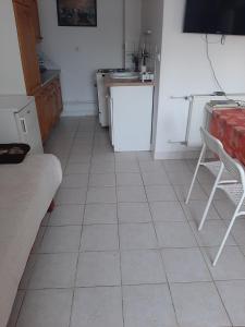 包道乔尼托毛伊Badacsonyi Panorámás magánszállás的厨房铺有白色瓷砖地板,配有白色冰箱。