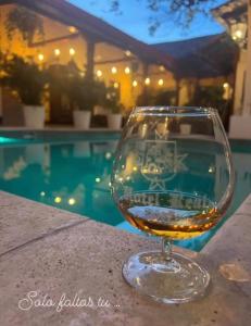 莱昂利昂酒店的坐在游泳池畔的桌子上喝一杯葡萄酒