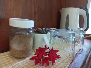 Marigot多米尼加宁静小屋酒店的一张桌子,上面放着一罐调味品和一朵红花