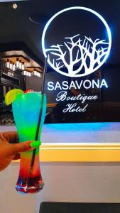 波罗瓜尼Sasavona Boutique Hotel的把五彩缤纷的饮料装在玻璃杯里的人
