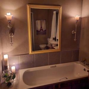 伊泽芳登Pause Studio Room Yzerfontein的带浴缸、镜子和盥洗盆的浴室
