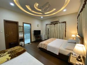 拉瓦尔品第Alpha Guest House的酒店客房设有一张大床和一个圆形天花板