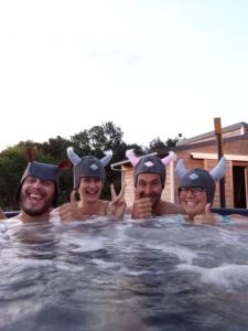 La BoissièreSpa & Bain Nordique - Tiny house à la campagne的一群三人在游泳池里穿着服装