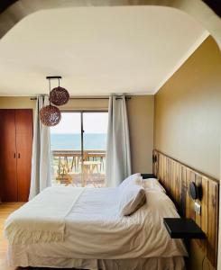 康康Blumen Hotel的一间卧室设有一张床,享有海景
