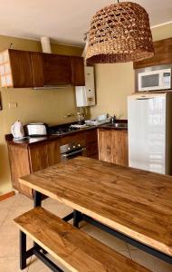 康康Blumen Hotel的厨房配有木桌和冰箱。
