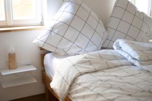 班贝格Concordia33 - Traumferienwohnung an der Regnitz的一间卧室配有带白色床单和枕头的床。