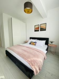 布加勒斯特Orhideea Central Apartments的一间卧室配有一张带粉色毯子的大床