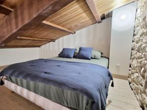 圣佩赖LE RELAIS DE CRUSSOL的一间卧室配有一张带蓝色枕头的大床