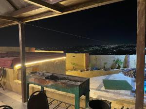 杰拉什Raghad Chalet的户外庭院在晚上配有桌椅