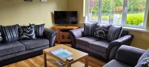 巴林罗布Reed Warbler Cottage的客厅配有两张沙发和一台电视机