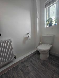 普里茅斯Entire 2 Bedroom House Modern Stylish Luxury的白色的浴室设有卫生间和窗户。