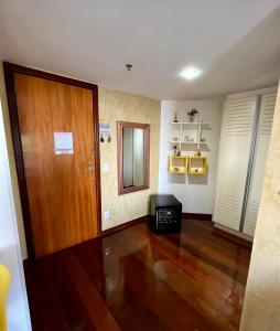 尼泰罗伊Apto com VISTA do Pão de Açúcar, VARANDA, PISCINA, SAUNA, ACADEMIA, COZINHA COMPLETA, GARAGEM, PORTARIA 24h e MINI MERCADO的客厅设有木门和木地板