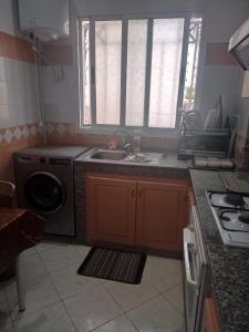 阿加迪尔أكادير حي السلام的厨房配有水槽和洗衣机