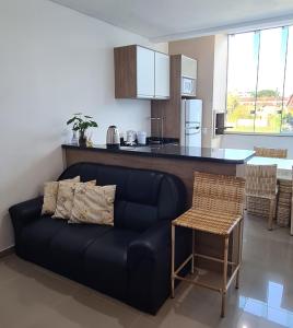 马蒂尼奥斯Apto completo praia Caioba的带沙发的客厅和厨房