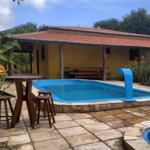 MartinsChácara Tantan - Martins RN的一个带桌椅的游泳池和一个房子