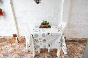 曼塔Habitaciones privadas, Casa de Amber, Manta的一张带两把椅子的白色桌子和一株植物