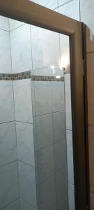 Saint-Pardoux-IsaacChez Audray的浴室内铺有白色瓷砖,设有玻璃淋浴间