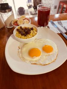 瓜亚基尔Fortune Hotel的桌上放有两个鸡蛋和一碗食物的盘子