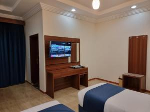 Al Qunfudhahالديار الفاخرة للشقق المخدومة的酒店客房,配有床和电视